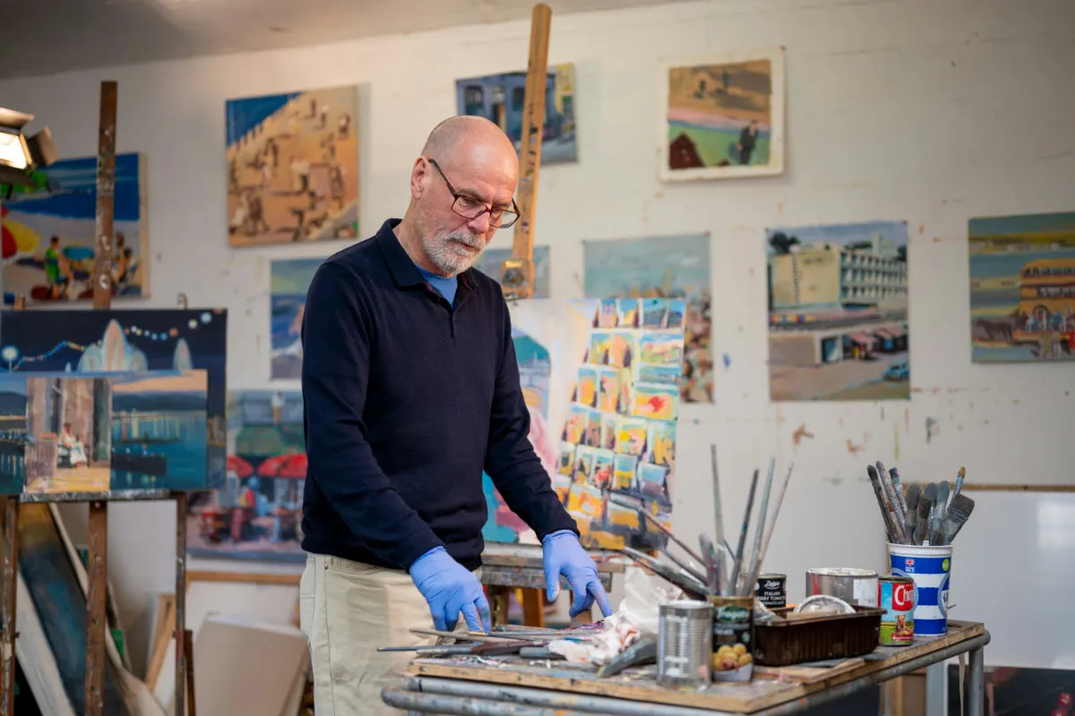 An older artist working in his studio